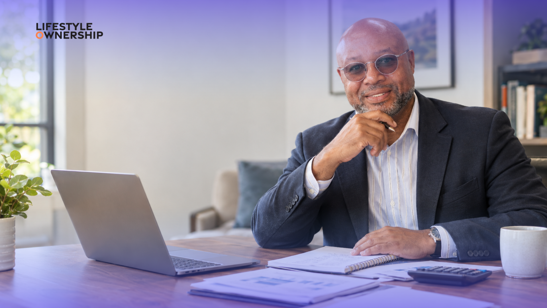 Person reviewing their finances with a notebook, calculator, and financial documents to identify where to start improving their money